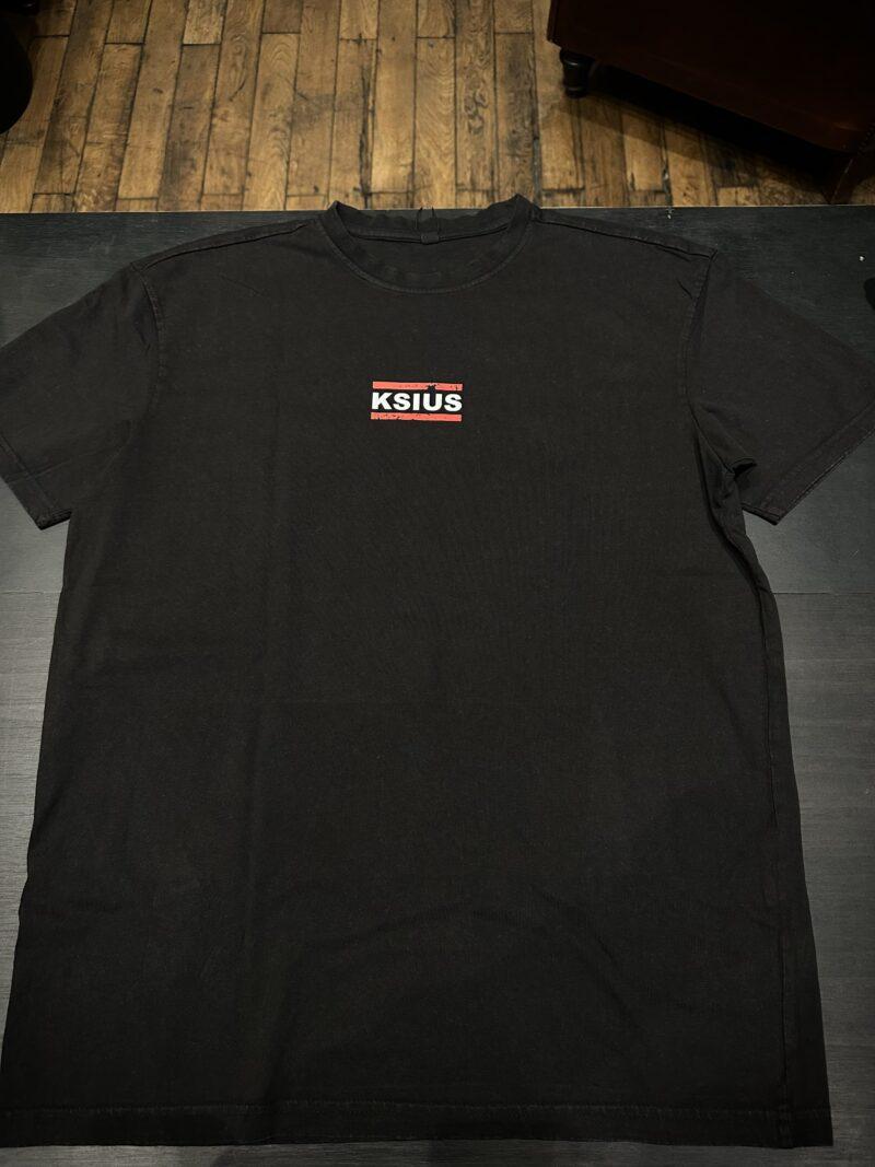 Photo du T-shirt noir avec un logo en dessous du col